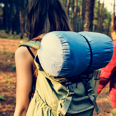 person hiking through forest with a backpack and sleeping bag for outdoor adventure and relaxation 2 activities 2 nature