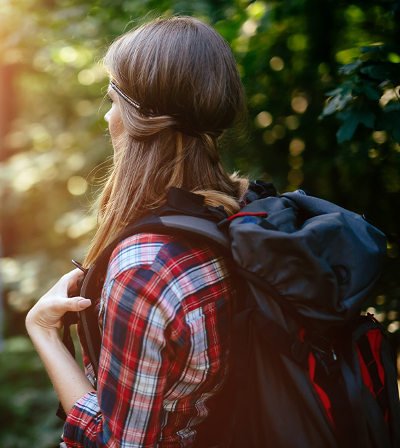 woman in plaid shirt carrying backpack in forest hiking outdoors adventure joyful nature 8 activities