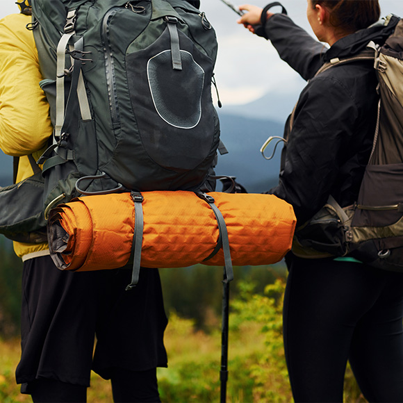 two hikers with backpacks standing on a mountain trail pointing at a distant view showcasing outdoor adventure and camping essentials 5 tips for hiking